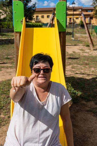 A closeup portrait of a happy attractive black hair mature woman smiling with sunglasses showing thumbs up