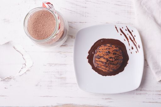A top view of chocolate ice cream scoop with chocolate topping and a cup of coffee