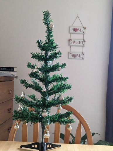 A beautiful shot of decorated artificial pine Christmas tree in the wooden table