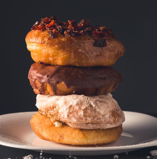 A vertical shot of assorted donuts on a plate