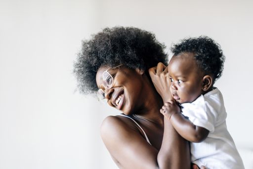 An African-American mother taking care and loving her baby against a white background