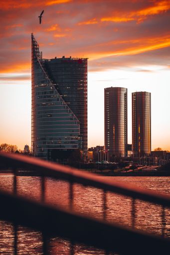 A vertical shot taken from Vansu bridge, three modern buildings in Riga at sunset