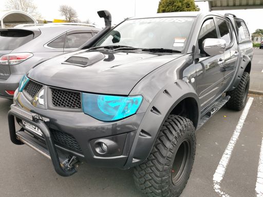 Auckland / New Zealand - September 24 2020: View of modified tuffed-up Mitsubishi Triton ute with blue headlight filter