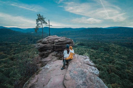 A closeup shot of a couple sitting on the edge of a rock