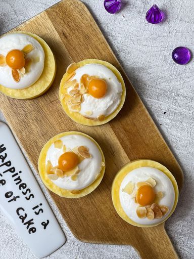 A top view of lemon tarts on a wooden cutting board
