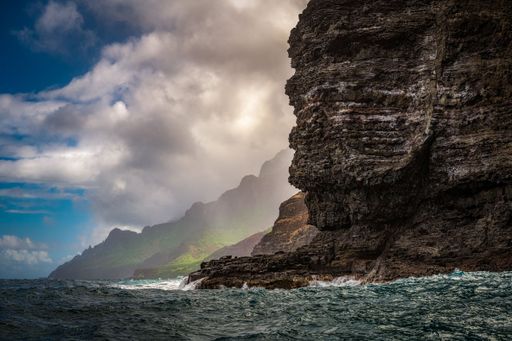 A mesmerizing shot of rugged mountain cliffs, rocks and clouds by the Napali coast near Kauai Hawai