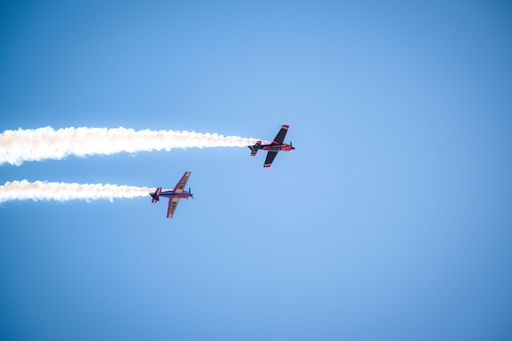 Two military fighter jets in flight performing an aerial display at an airshow