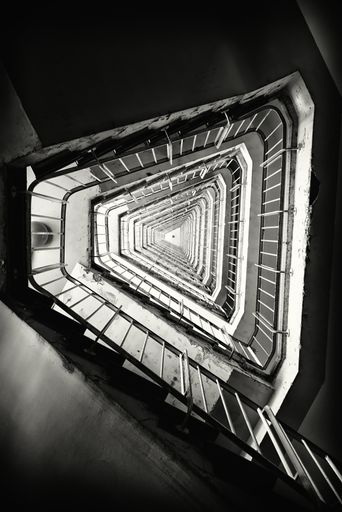 A vertical grayscale shot of a staircase in a building