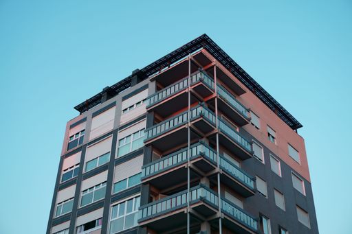 A closeup shot of a facade of a modern residential building with balconies against clear blue sky