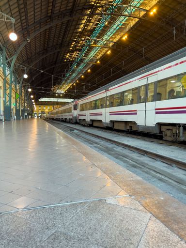 vertical shot of a modern red and white train waiting for passengers in a lonely station with a platform where there are no people