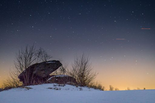 A beautiful starry night in front of a snow-covered mountain slope perfect for wallpapers
