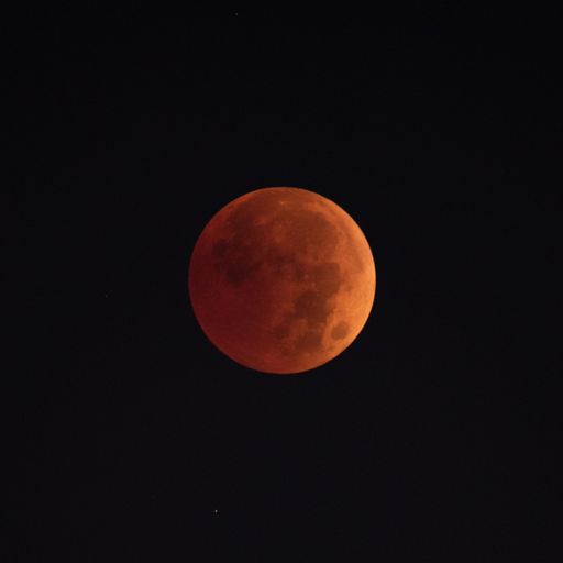 A scenic view of the lunar eclipse in the dark sky at night
