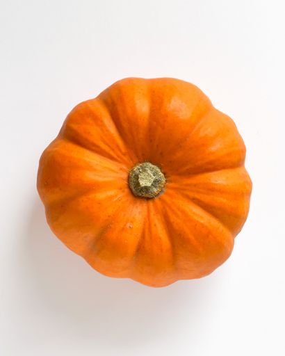 A top view of an orange pumpkin, studio photoshoot on a white background