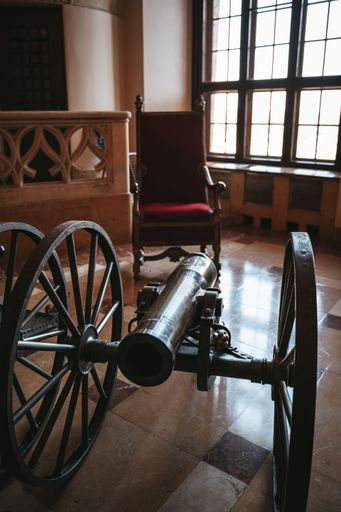 The interior of Hohenzollern Castle with cannon and chair in the room