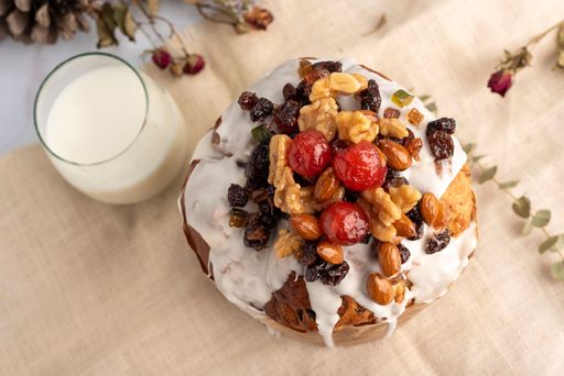 A closeup of sweet bread for the Christmas holiday with dry fruits and cream on a table