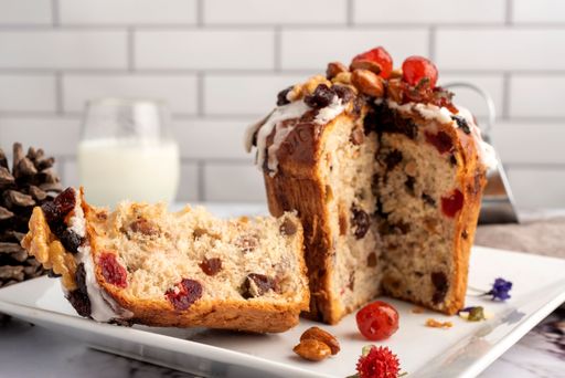 A closeup of sweet bread for the Christmas holiday with dry fruits and cream on a table