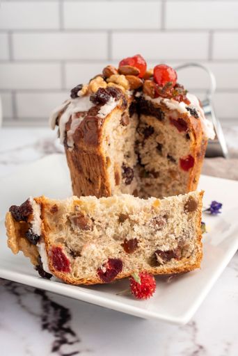 A closeup of sweet bread for the Christmas holiday with dry fruits and cream on a table