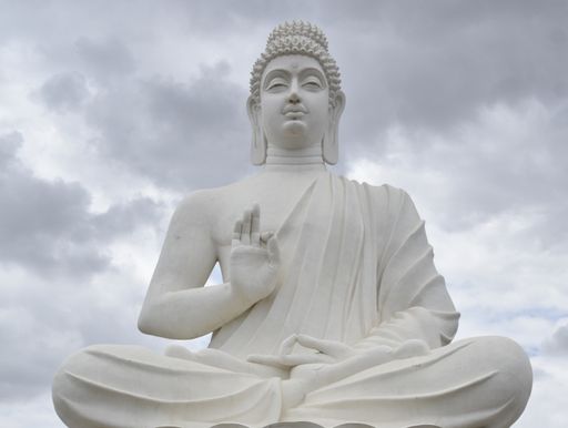 A huge statue of Buddha against the cloudy sky