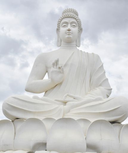 A huge statue of Buddha against the cloudy sky