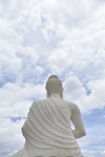 A huge statue of Buddha against the cloudy sky