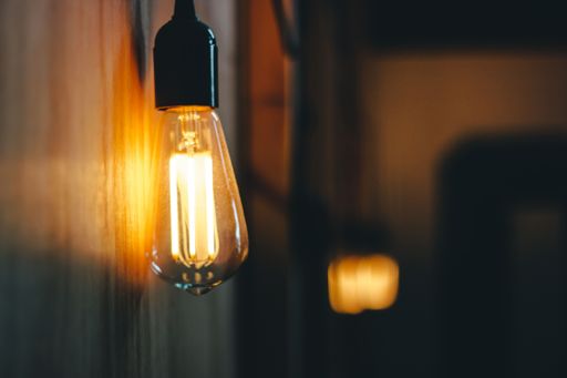A selective focus shot of a lamp spreading light around in the middle of a room