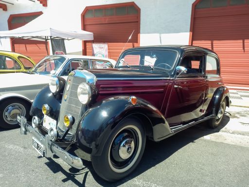 Old red burgundy and black 1953 Mercedes Benz 170 SD w136 four door sedan in the street. Expo Warnes 2022 classic car show.