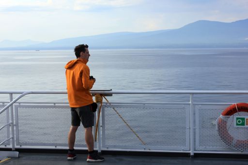 The passenger on the deck of the BC Ferry near Vancouver with mountains and the ocean in the background