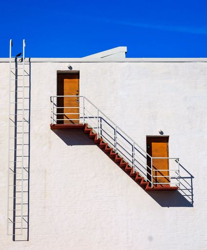 A closeup of a grey metal stairs on the side of a minimalistic building captured in Helsinki