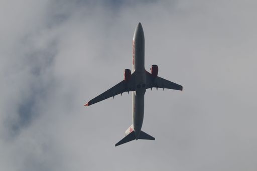 The Boeing 737-900ER of Thai Lion Air flying in the cloudy sky
