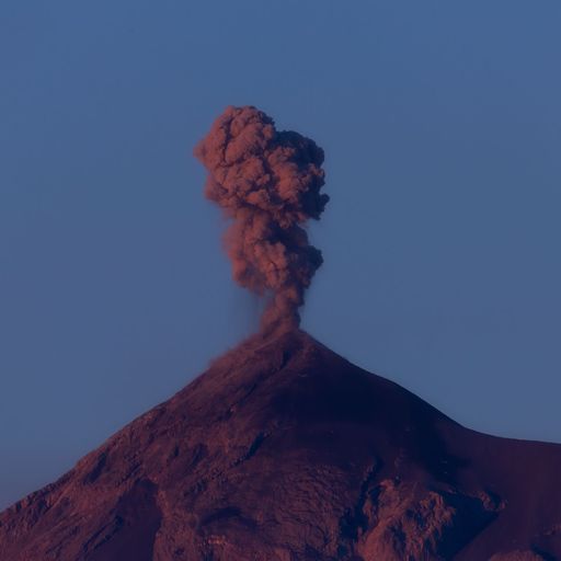 A mountain eruption with the smoke against the blue clear sky