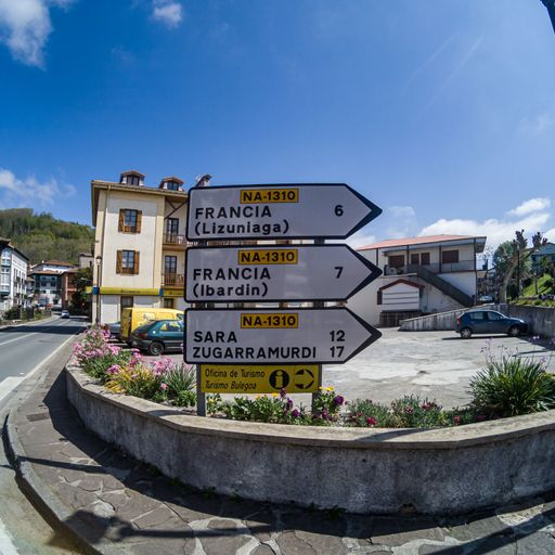 Road signs to french borders near Irun in Spain, Fisheye view of crossroad with blue sky in traditional Spanish village.