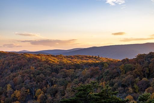 The Shenandoah National Park with forests and hills under a sunset sky during the fall