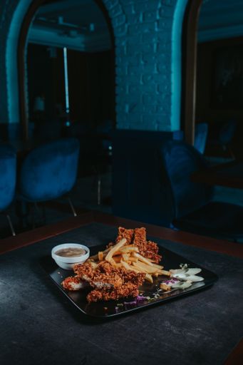 A  closeup shot of a tasty looking dish with fried chicken and french fries