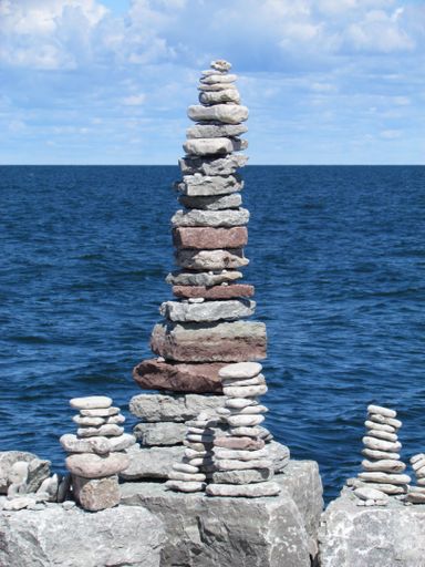 A vertical closeup shot of stones stacked on top of each other on the coast of an ocean