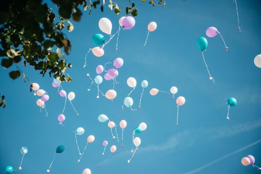 A low-angle shot of the Colorful balloons with cards in the sky