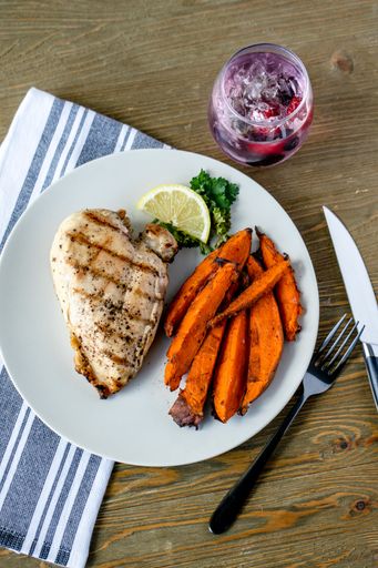 a vertical closeup shot of a plate of Chicken Breast with Sweet Potato Fries