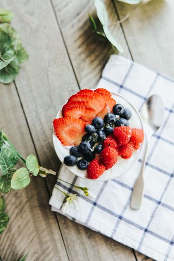 a Vertical High angle closeup of a dessert bowl with Strawberries Blueberries and Raspberries