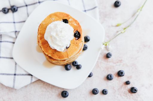 A closeup shot of Blueberry Pancakes with Whipped Cream
