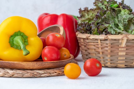 A close-up shot of colorful vegetables in a wooden basket and a plate