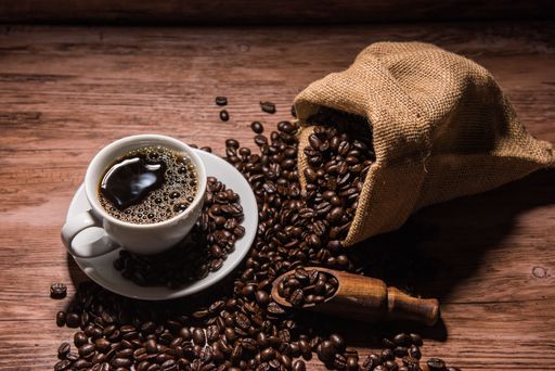 A top view of a cup of strong espresso and coffee beans in a bag