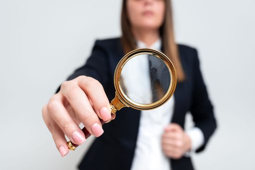 Businesswoman Holding Magnifier In One Hand. Woman Having Magnifying Glass To Point. Lady In Suit Zooming Message. Executive Presenting Idea.