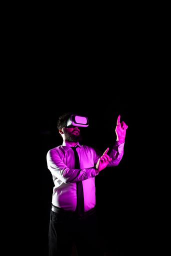 Businessman Using Virtual Reality Goggles Gesturing While Training. Light Falling On Man Experiencing Simulator And Presenting Technology.