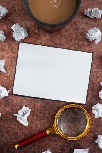 Blank Sheet With Magnifying Glass, Coffee Cup Surrounded With Crumpled Papers Over Wooden Background. It Is Presenting Analyzing Of Plans 