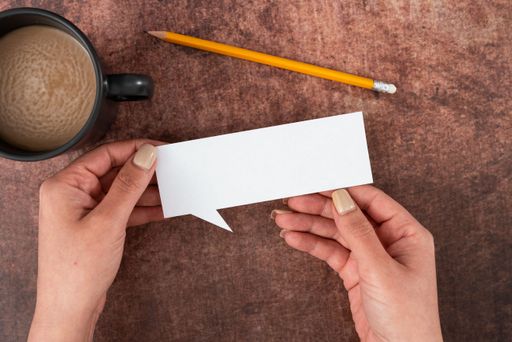 Woman With Speech Bubble Of Empty Paper, Coffee Cup And Pencil Over Wood. Businesswoman Holding Blank Sheet And Representing Thoughts 