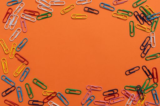 Colorful Paperclips Placed Around Information. Colored Clips Arranged In Circle With Crutial Announcement Inside. Staples With Ideas Written In.