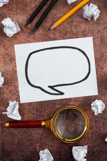 Paper With Speech Bubble Drawing, Magnifying Glass And Pencil With Crumpled Papers Over Wood. It Is Representing Brainstorming New Ideas For Business.