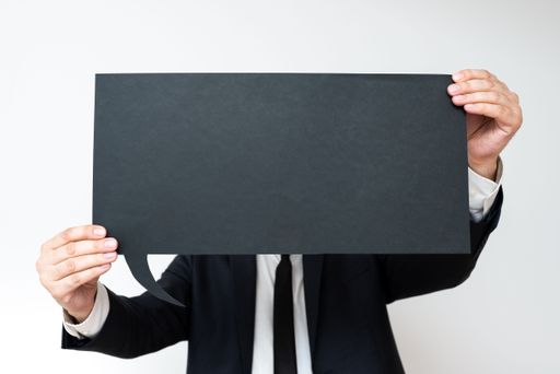 Businessman Holding Speech Bubble With Messages. Man In Suit Presenting Crutial Information On Dialogue Balloon. Gentleman Showing On Paper.