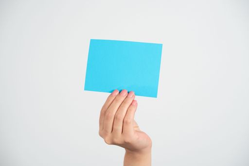 Businesswoman Holding Note With Message With One Hand. Woman Presenting Information On Piece Of Paper. Executive Showing Critical Announcement.