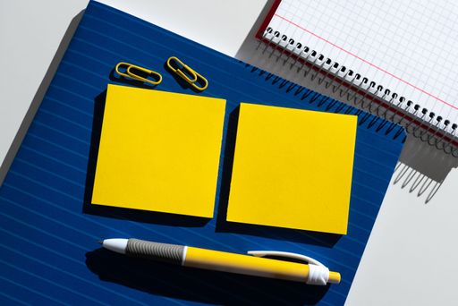 Messages Presented On Two Sticky Notes On Desk With Notebook, Clips And Pen. Information Written On Memos With Notepad. Critical Ideas Shown.