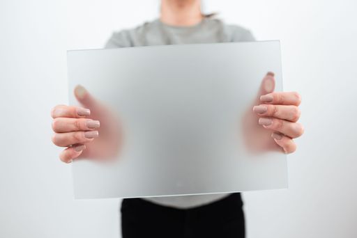 Businesswoman Holding Blank Placard And Presenting Sales Data. Female Worker Wearing Smart Casual And With Banner In Hands Advertising The Business.